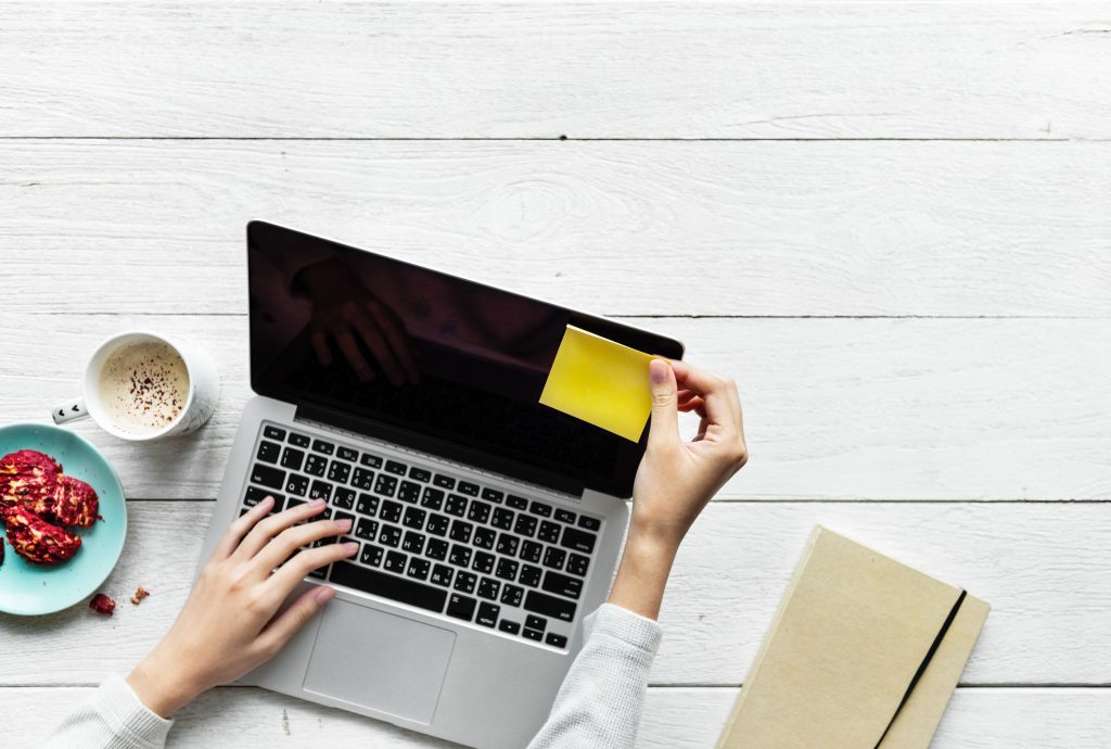 computer with a sticky note on a desk