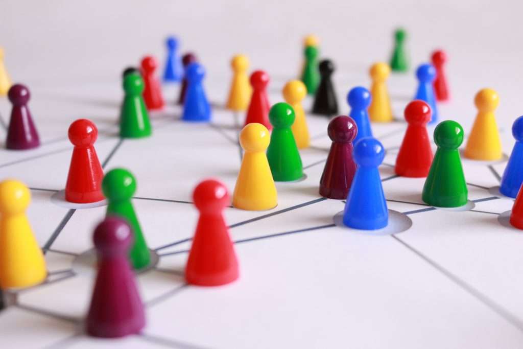 Close Up Photography of Yellow Green Red and Brown Plastic Cones on White Lined Surface symbolizing social networking 